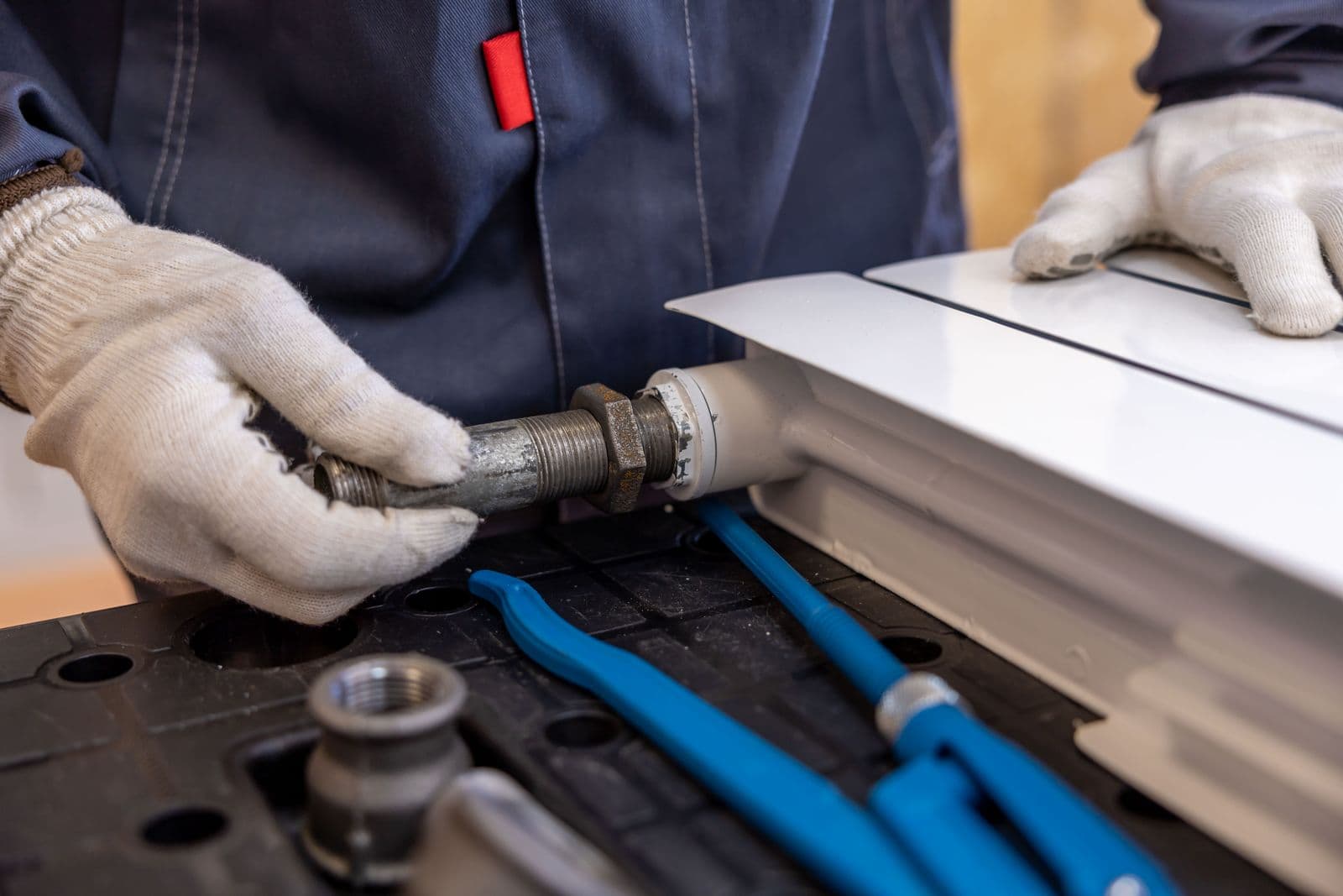 Close-up of a pro installing a pipe fitting with specialized tools